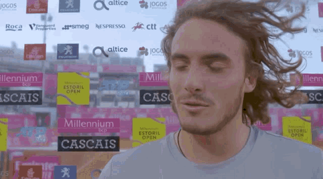 a man with his eyes closed stands in front of a wall that says millennium
