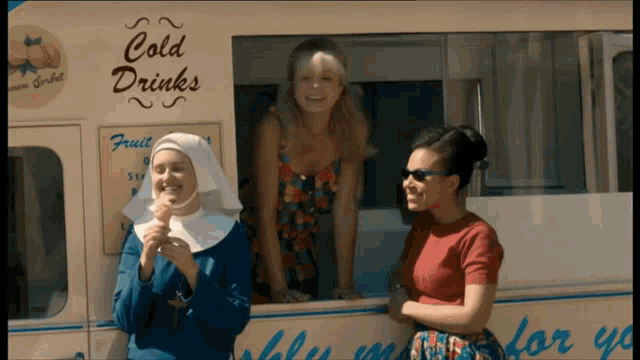 three women are standing in front of an ice cream truck that says cold drinks