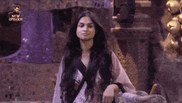 a woman with long black hair is standing in a room with a new episode written on the bottom of the screen