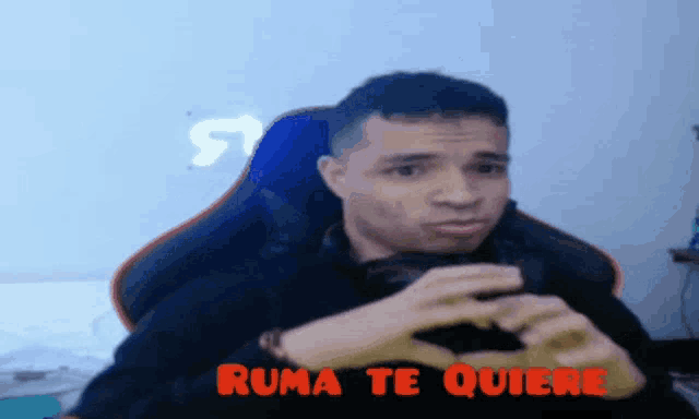 a man is making a heart shape with his hands and the words " ruma te quiere " written above him