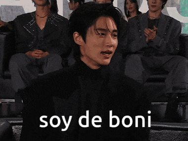 a man in a suit is sitting in front of a crowd and says soy de boni