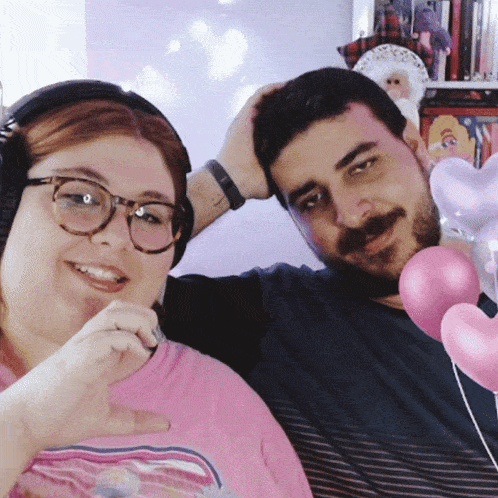 a man and a woman are posing for a picture and the woman is wearing headphones