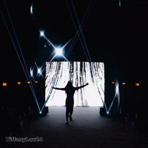 a silhouette of a woman standing in front of a large screen with tiffanyluv24 written on the bottom right
