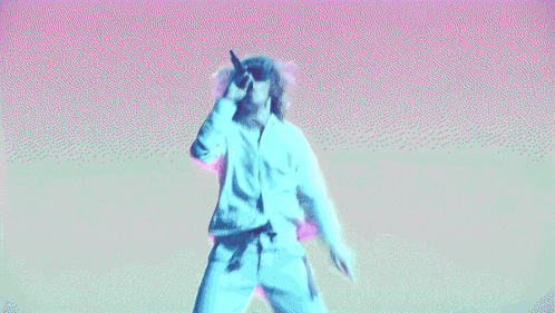 a man singing into a microphone with a pink and blue background
