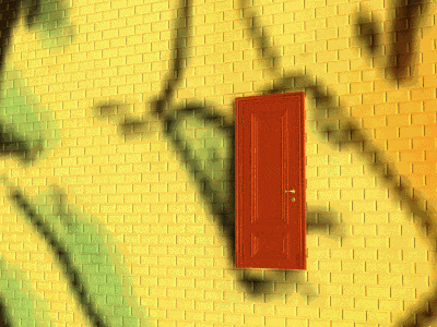 a yellow brick wall with a red door in the corner