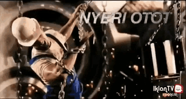 a man wearing a hard hat is working on a machine with the words nyeri oto written on the bottom
