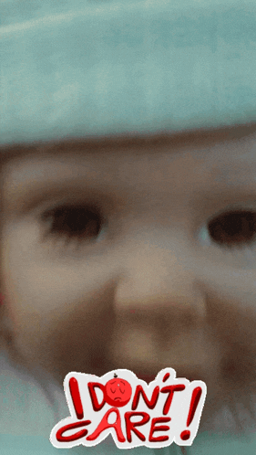 a close up of a baby 's face with a sticker that says do n't care