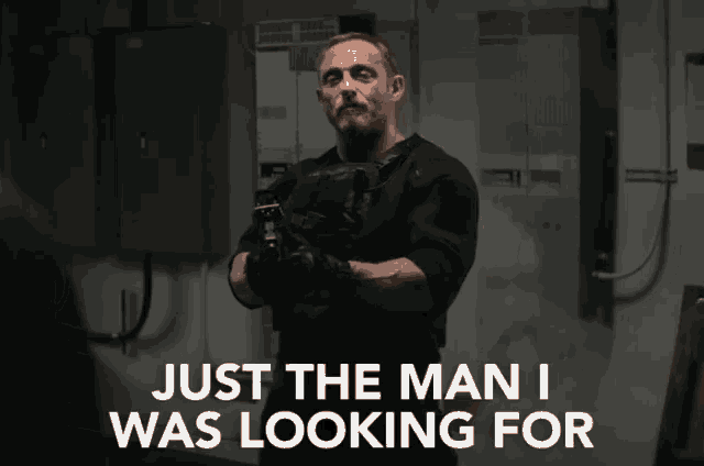 a man holding a gun with the words just the man i was looking for above him