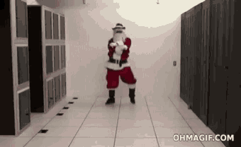 a man dressed as santa claus is dancing in a hallway in a server room .