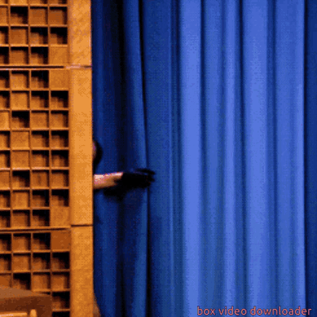 a blue curtain is behind a box with the words box video downloader on the bottom