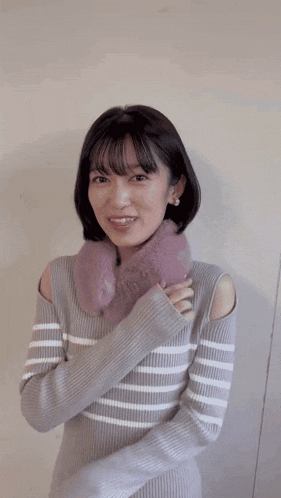 a woman wearing a striped sweater and a furry scarf around her neck