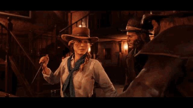 a man with a beard wearing a cowboy hat is talking to another man in a dark room .