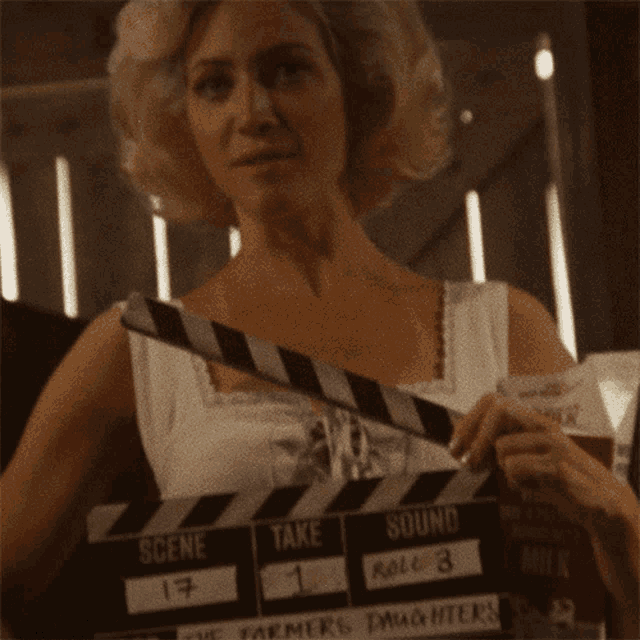 a woman holding a clapper board that says the farmers daughters