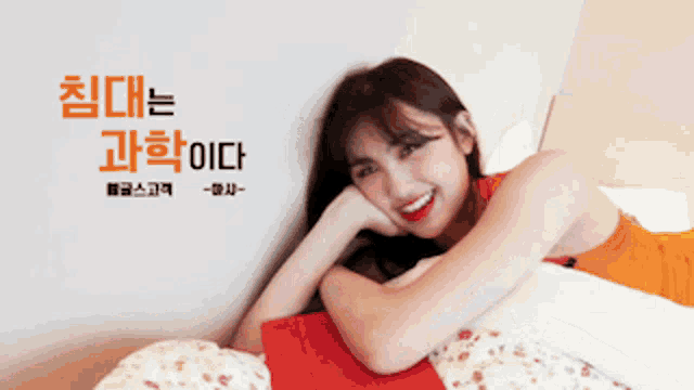 a woman in an orange dress is laying on a bed in front of a wall with chinese writing on it