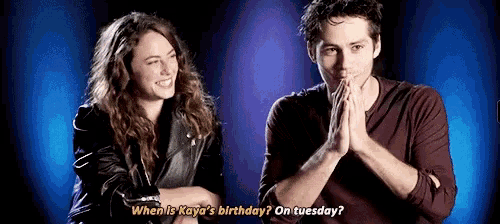 a man and a woman are standing next to each other and the man is asking the woman when is her birthday .