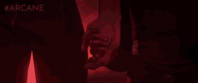 a person holding another person 's hand in a dark room with #arcane written on the bottom