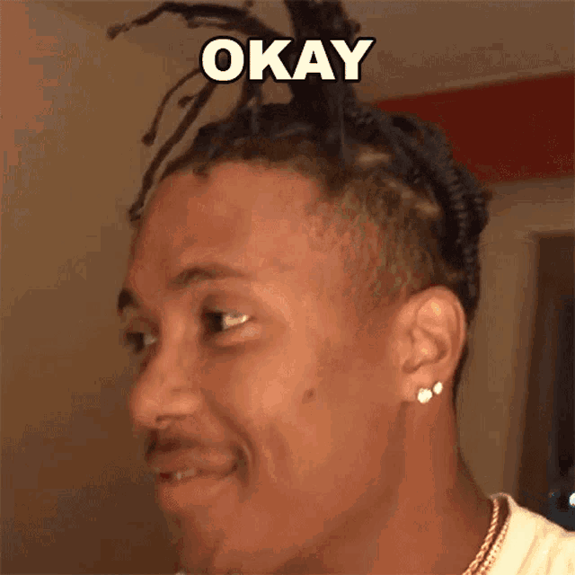 a man with dreadlocks has the word okay written on his face