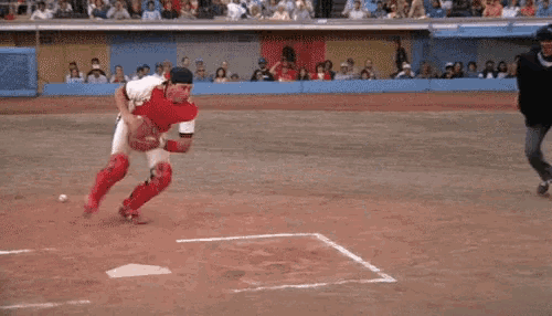 a baseball player wearing the number 32 is sliding into base