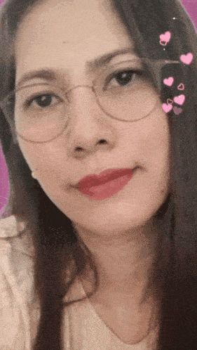 a woman wearing glasses and red lipstick is smiling for the camera .