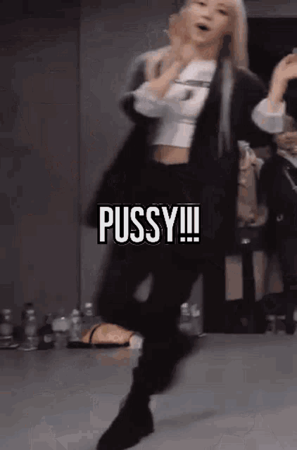 a woman is dancing in a room with the word pussy on the screen