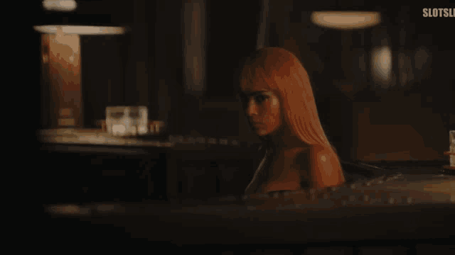 a woman with pink hair is sitting in a bathtub with the word slots in the bottom right corner