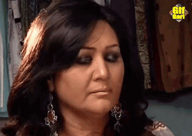 a close up of a woman 's face with a gif card in the background