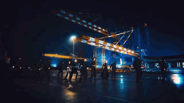 a group of people are dancing in front of a large crane that says ' lg ' on it