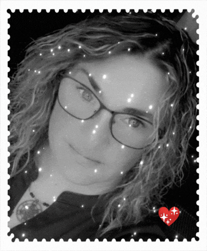 a black and white photo of a woman wearing glasses with a red heart in the corner
