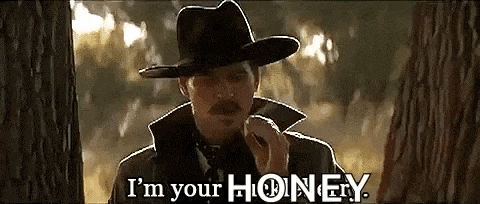a man in a cowboy hat is standing next to a tree and says i 'm your honey .