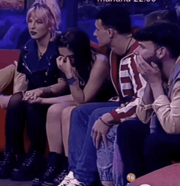 a group of people sitting on a couch with the number 16 on the bottom left