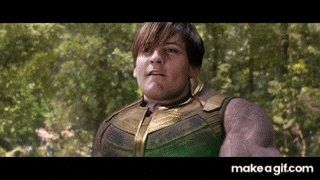 a man in a green and gold suit is standing in the woods .