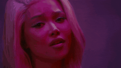 a close up of a woman holding a knife in her hand in a dark room .
