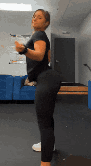 a woman in black leggings is standing in a room