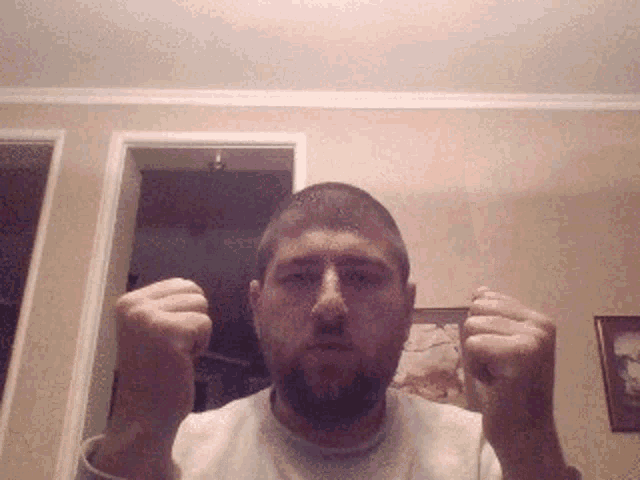 a man with a beard is making a fist gesture