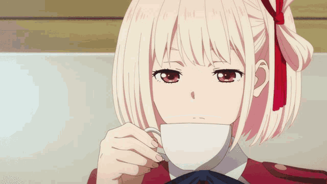 a girl with a red bow on her head drinking from a white cup