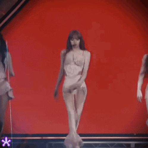 a woman in a white corset is walking on a stage .