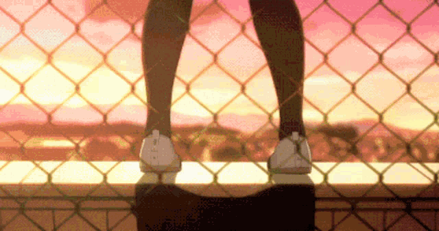 a person standing on top of a fence with their feet up