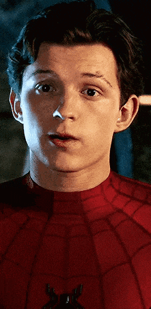 a close up of a man wearing a spiderman costume making a surprised face .