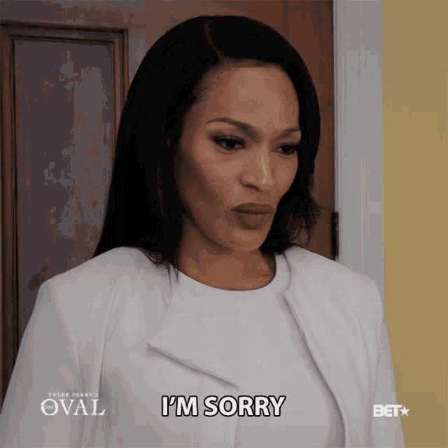 a woman says i 'm sorry while standing in front of a door