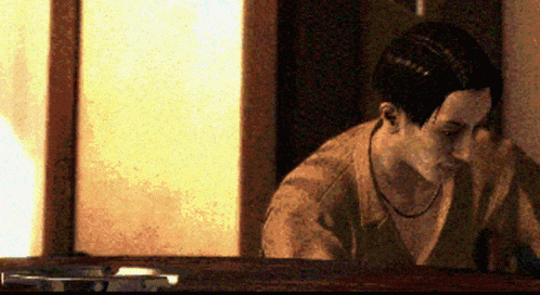 a man sitting in front of a window looking down