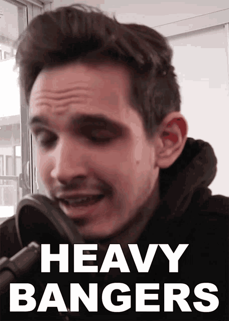 a man singing into a microphone with the words " heavy bangers " above him