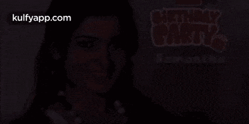 a woman is smiling in front of a sign that says birthday party samantha