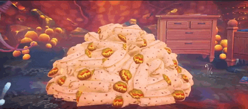 a pile of blankets with a dresser in the background