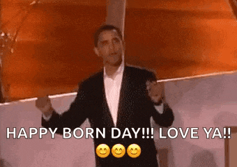 a man in a suit and tie is standing in front of a sign that says `` happy born day !!! love ya ! ''
