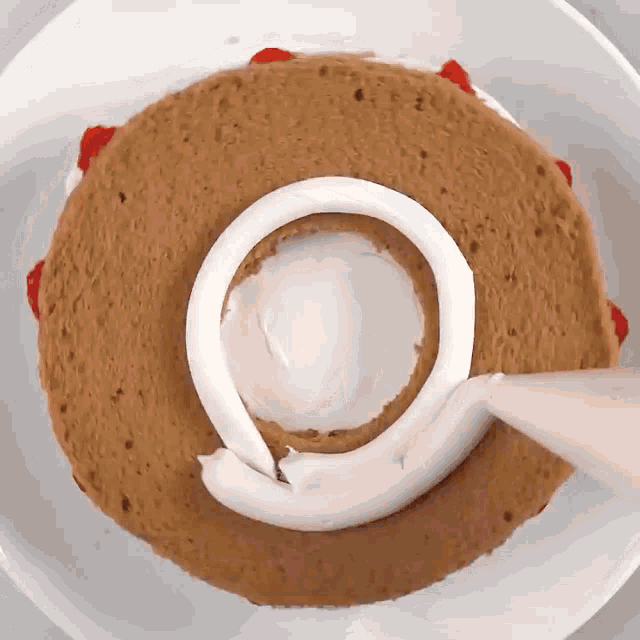 a cake is being decorated with white frosting on a plate