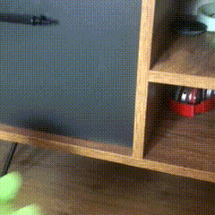 a wooden shelf with a gray door and a red object on it