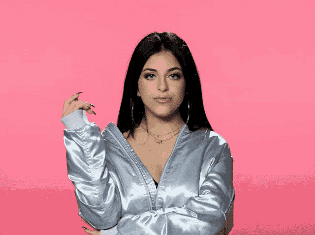 a woman in a satin jacket is standing with her arms crossed