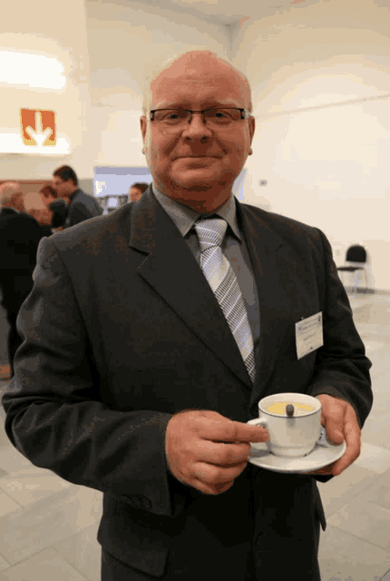 a man in a suit holding a cup of coffee