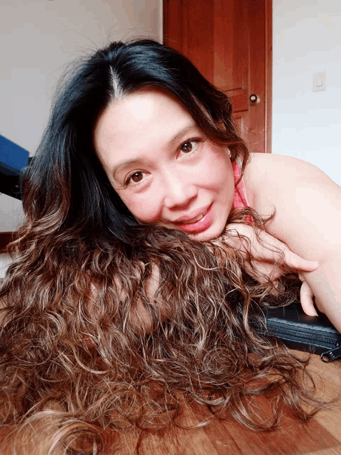 a woman laying on the floor with her hair on her head