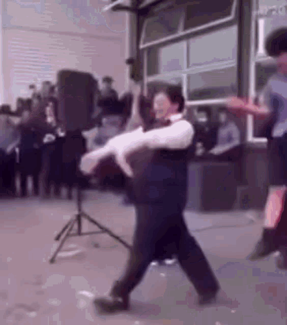 a man and woman are dancing in front of a crowd in a room .